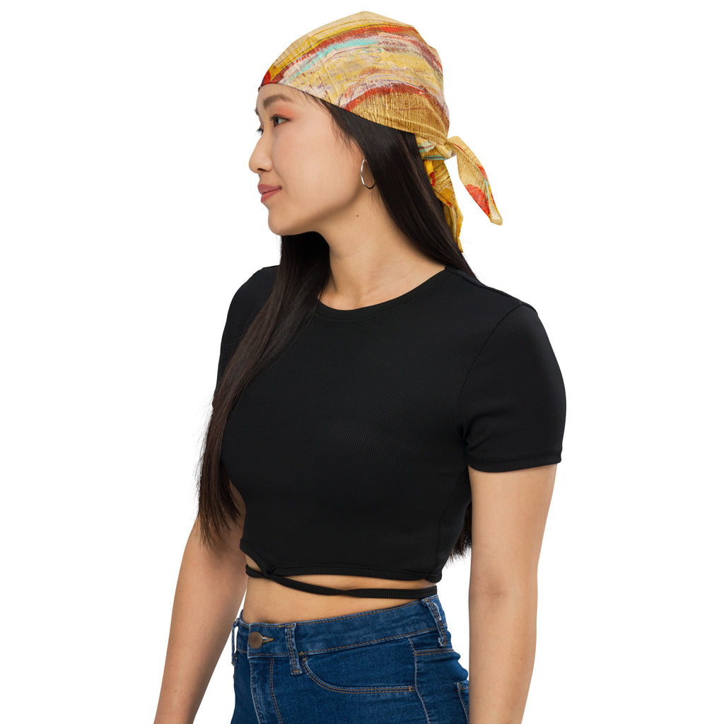 Side profile of model in a black crop top wearing the gold bandana tied over the head