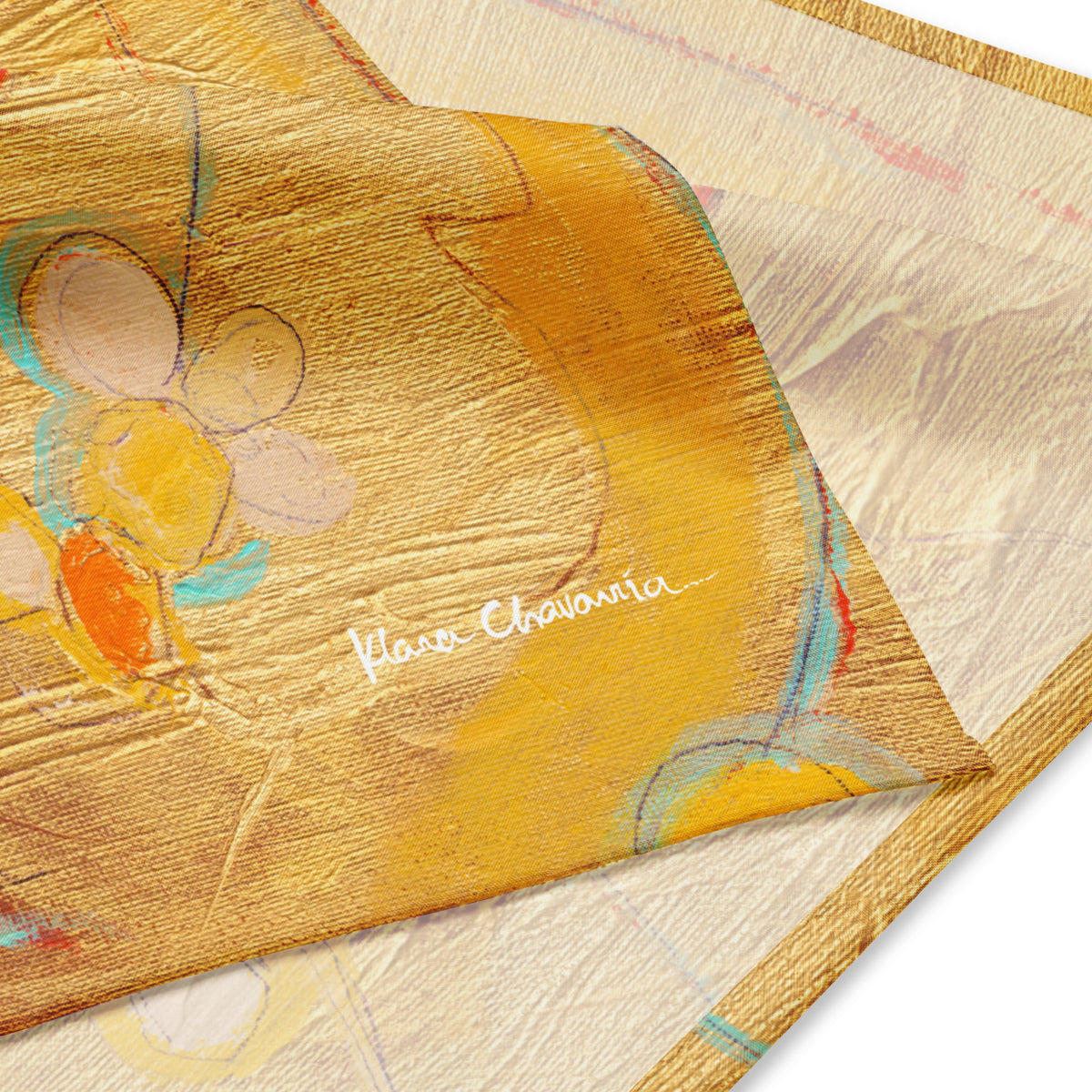 Close-up of the folded bandana corner with a pale flower, orange petal and white signature on gold