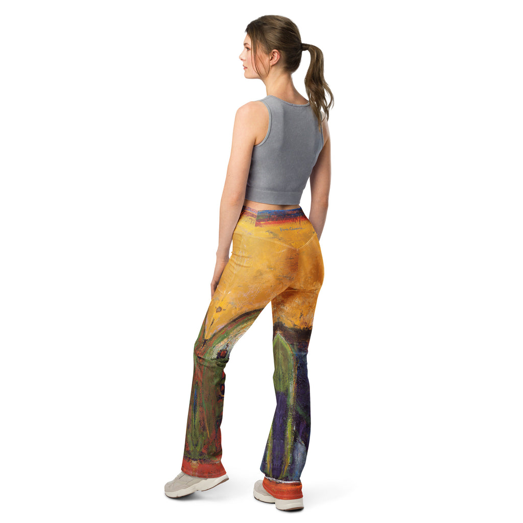 Back view of model with a ponytail in golden yellow flare leggings with purple and green lower legs