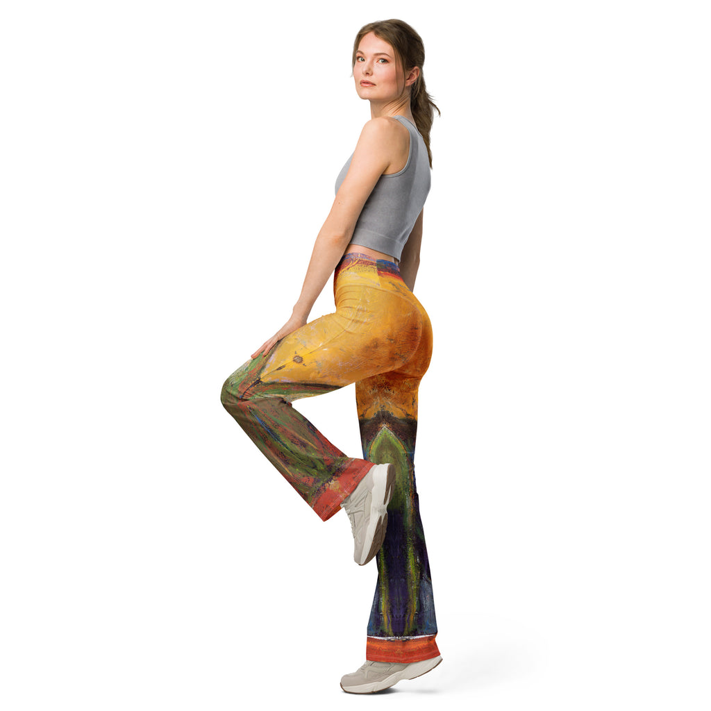 Model balancing on one leg in the yellow flare leggings with red hems, looking back
