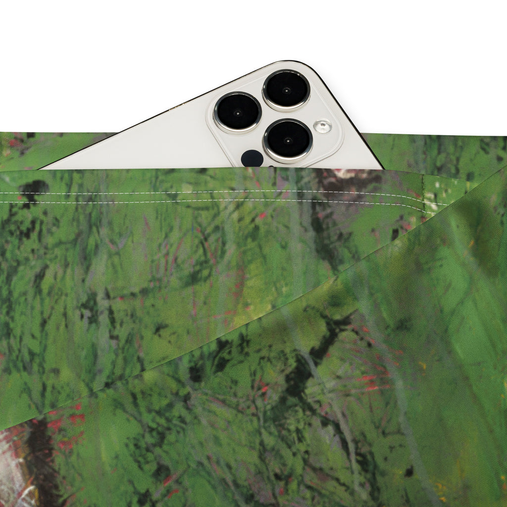 Close-up of a phone tucked into the inner waistband pocket of the green printed leggings