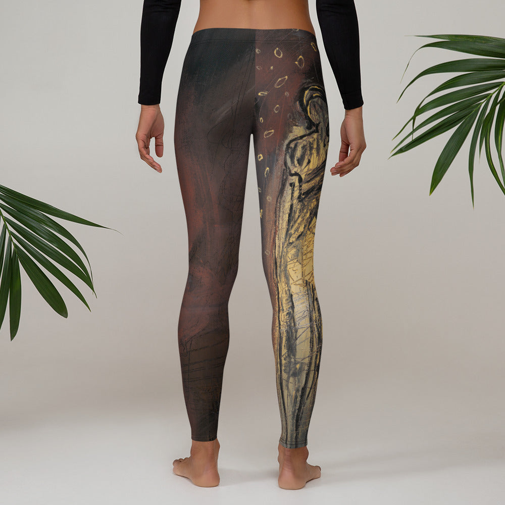 Barefoot model from behind, gold figure on one leg, palm fronds on either side