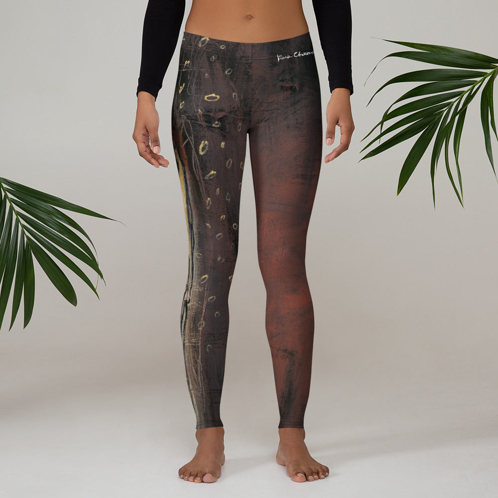 Barefoot model in a black long-sleeve top, front of the leggings beside palm fronds