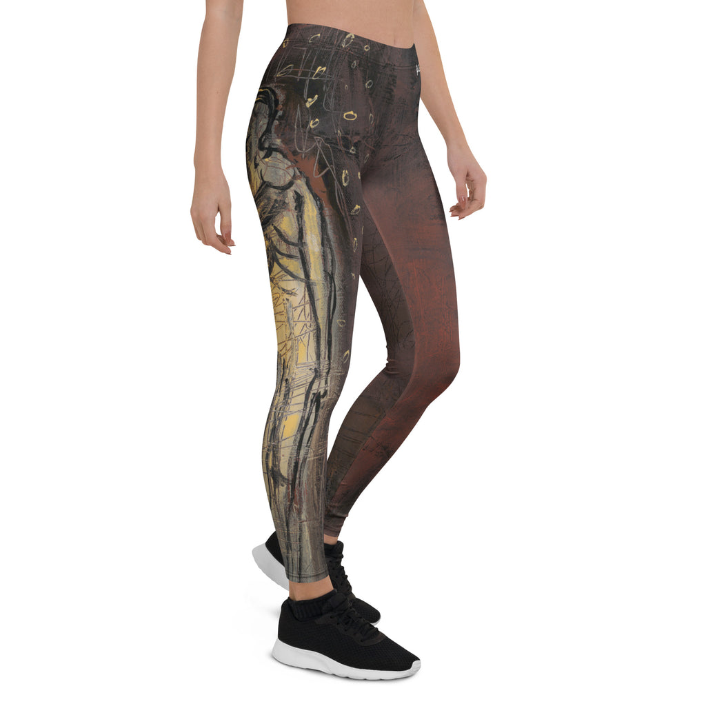 Three-quarter view of brown leggings with a gold sketched figure on one leg and black sneakers