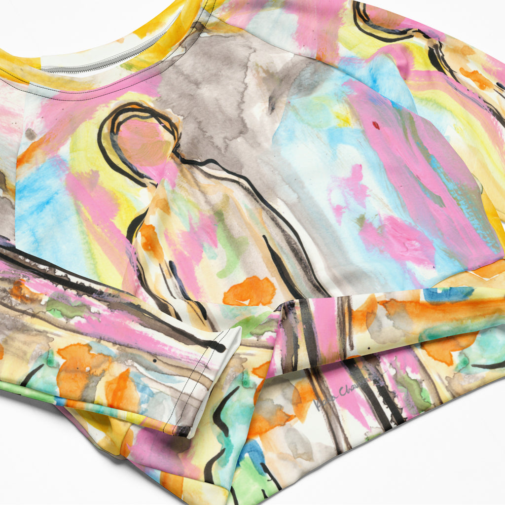 Close-up of the folded crop top showing a black-outlined figure, orange blooms and gray washes