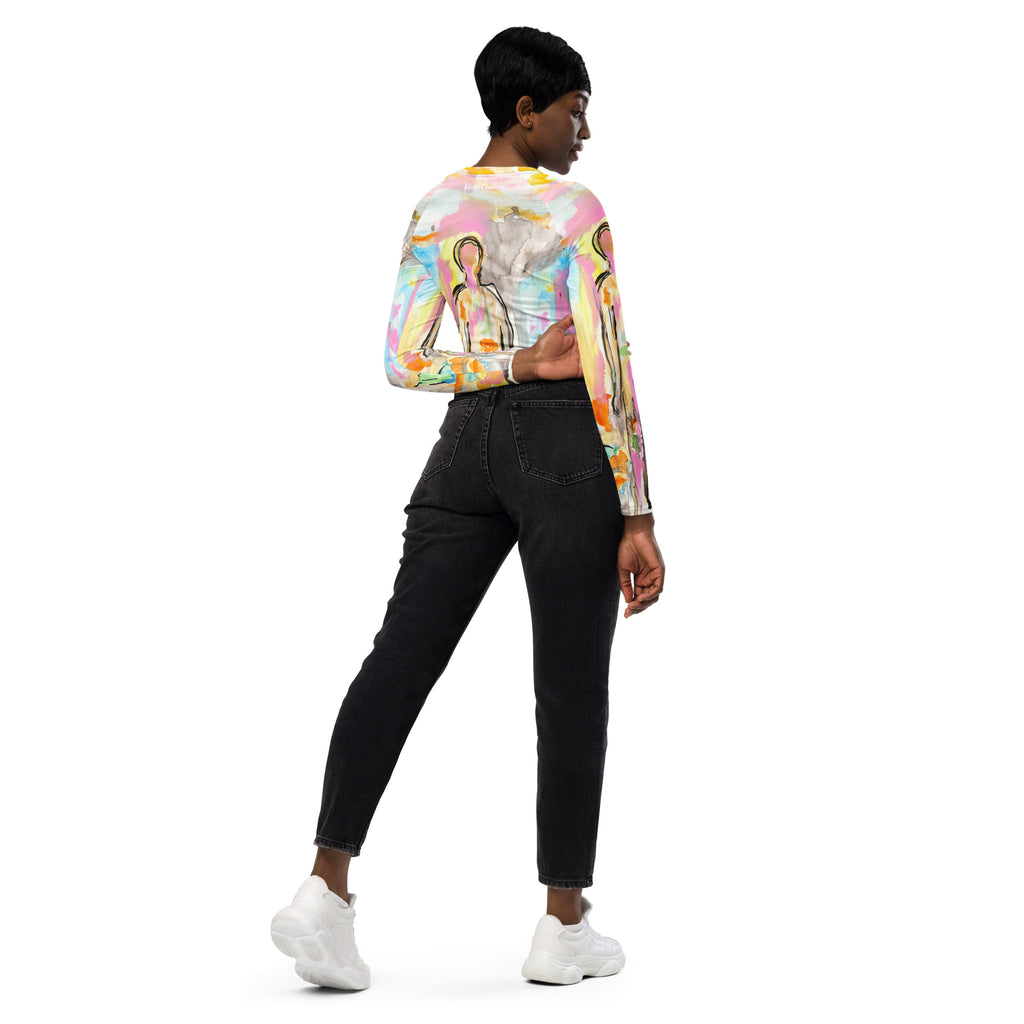 Model turned away looking over her shoulder in the pastel crop top and black jeans