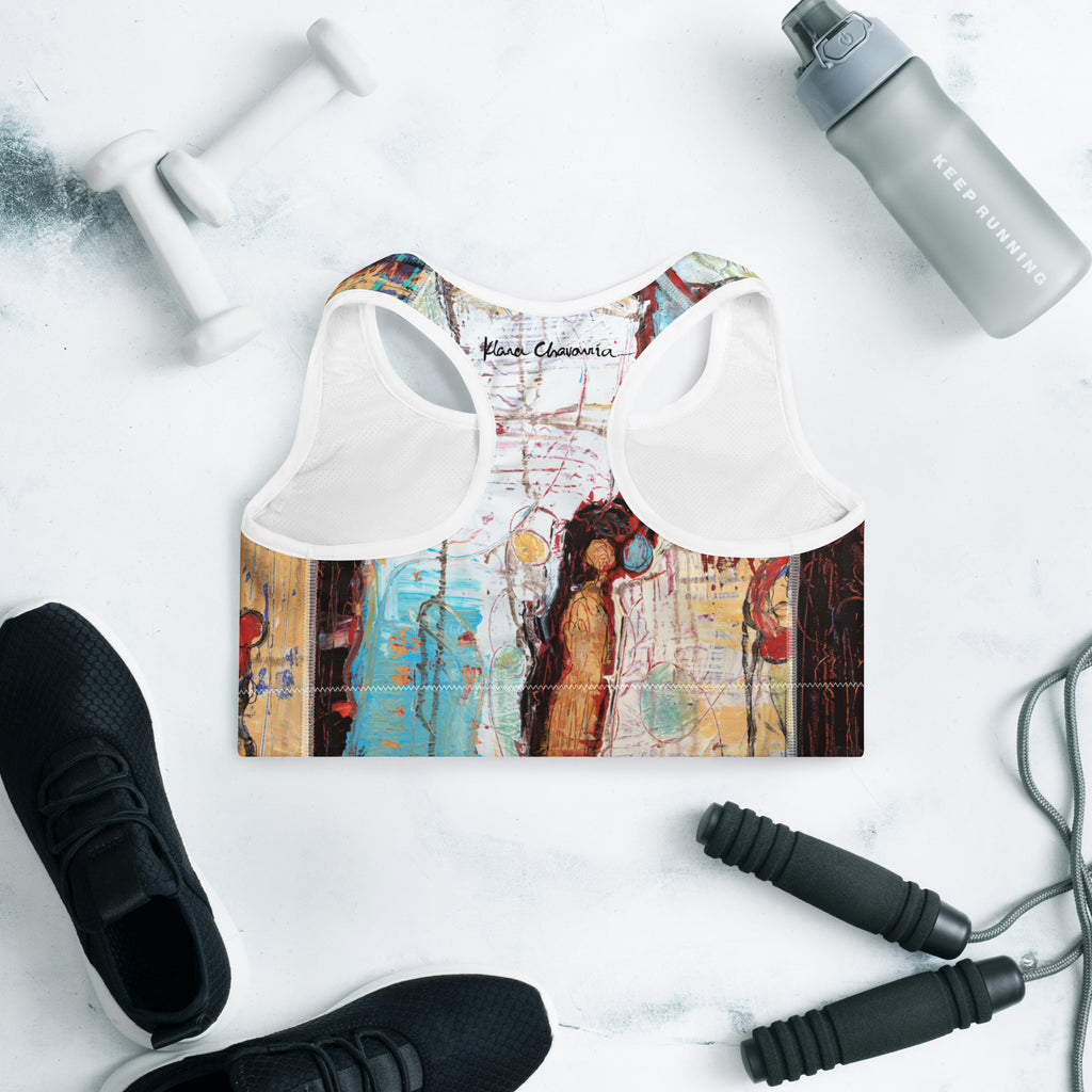 Racerback side of the bra laid flat with signature, surrounded by workout gear on marble