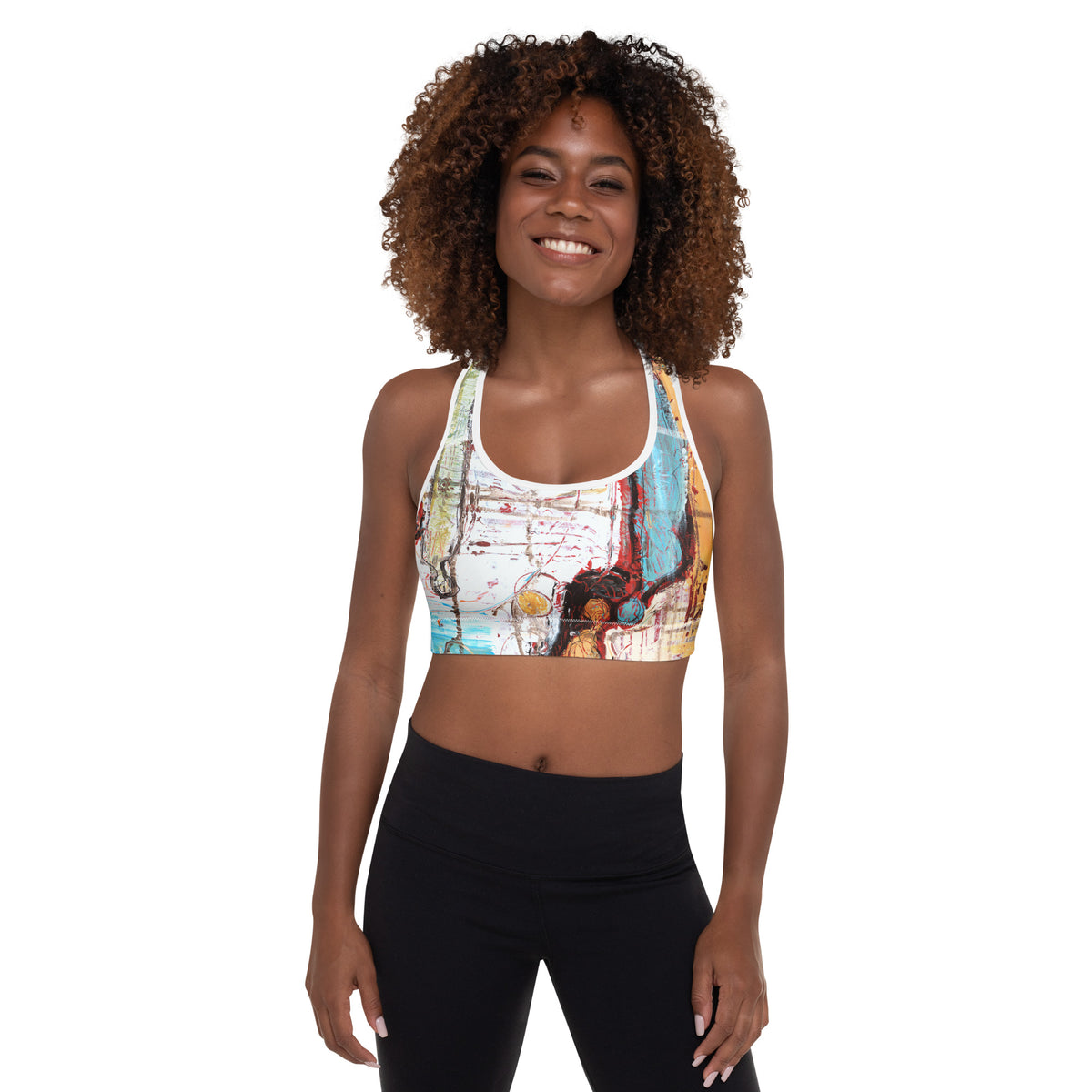 Smiling model with curly hair facing forward in the sports bra and black leggings