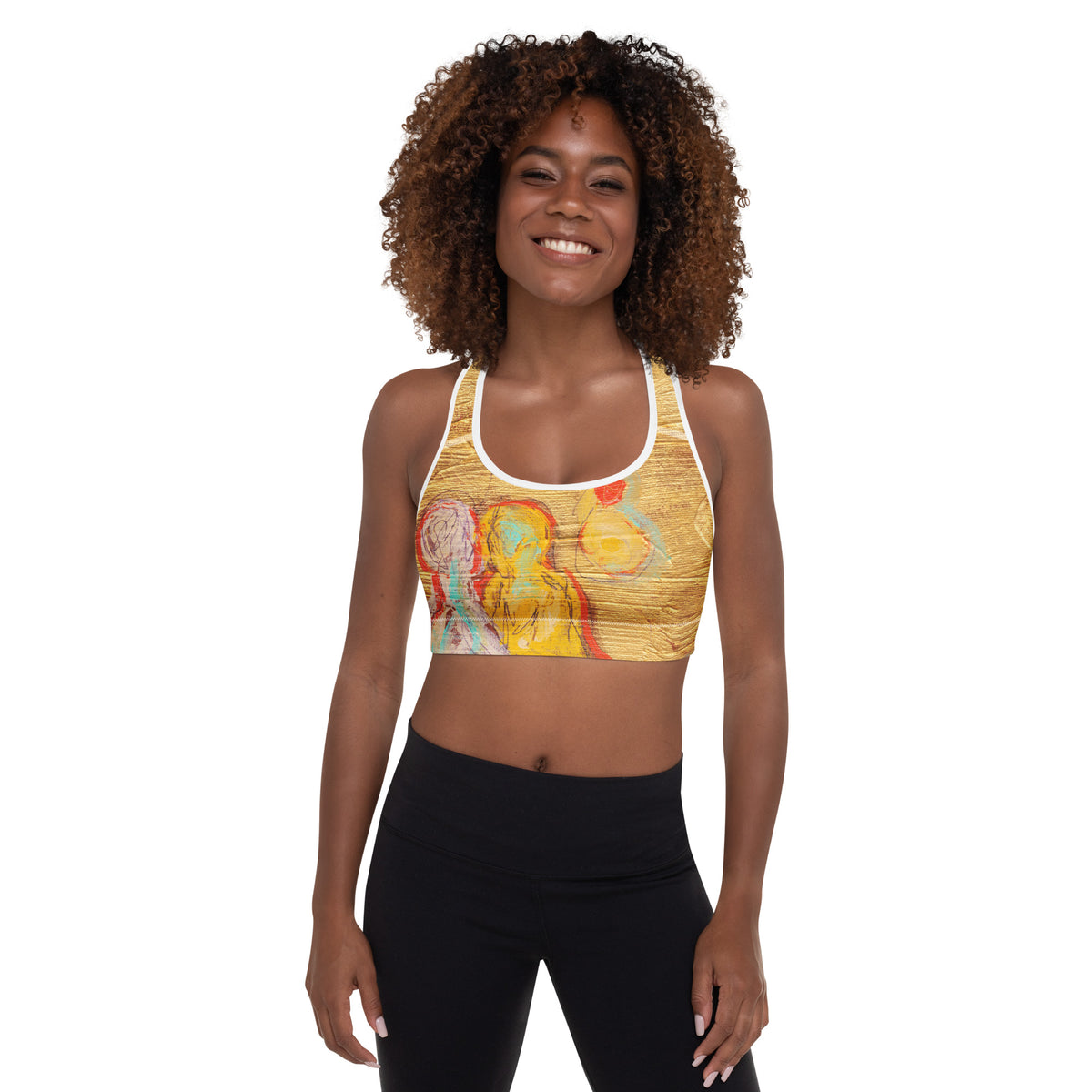 Smiling model facing forward in the gold sports bra and black leggings