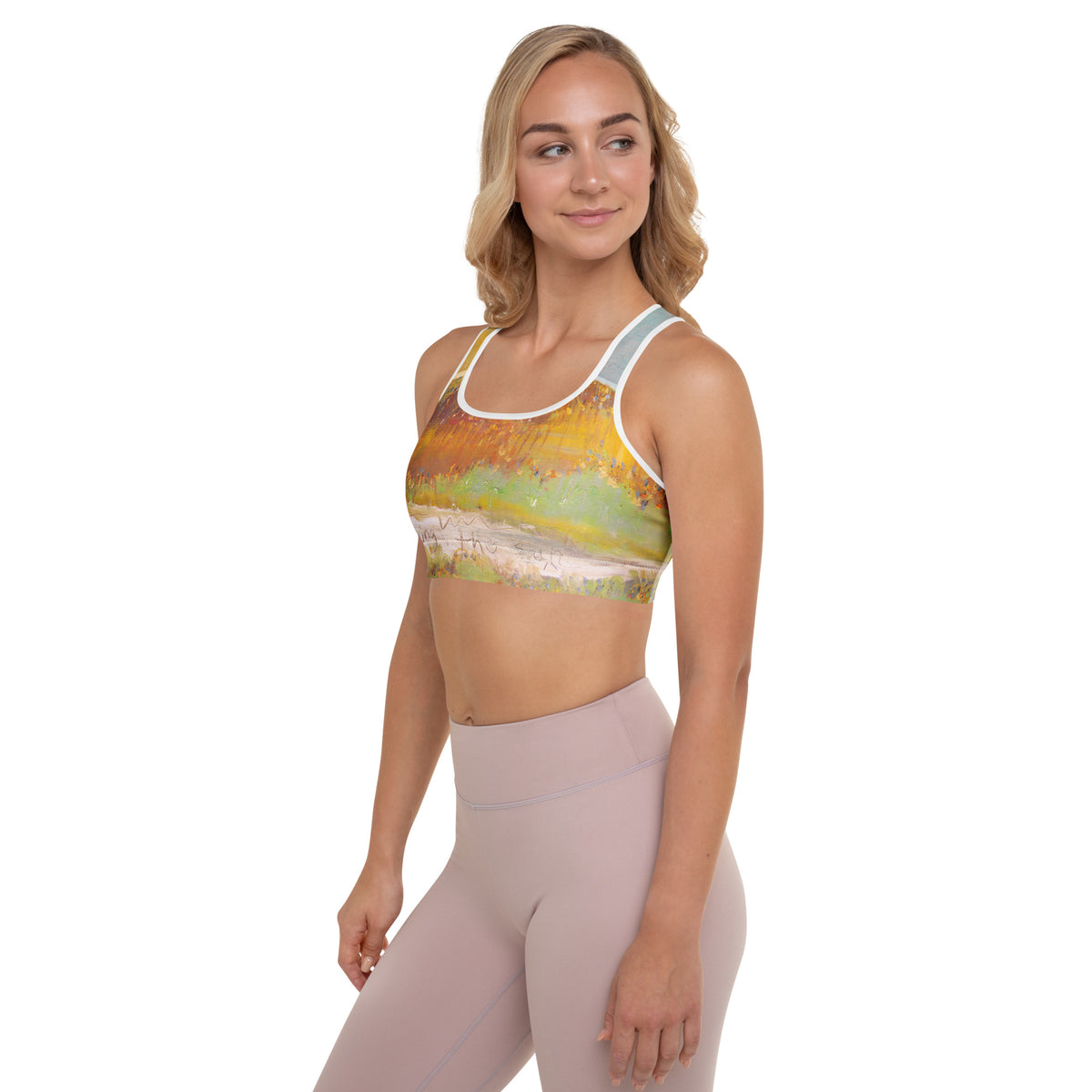Blonde model in side view looking away, bra showing gold and green strokes over a pale band