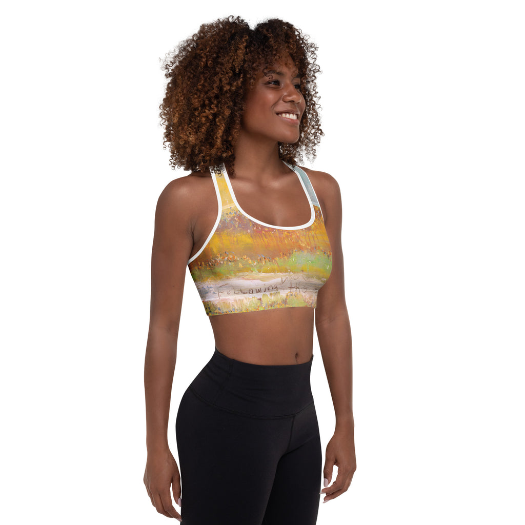 Smiling model with curly hair in three-quarter view in the sports bra and black leggings