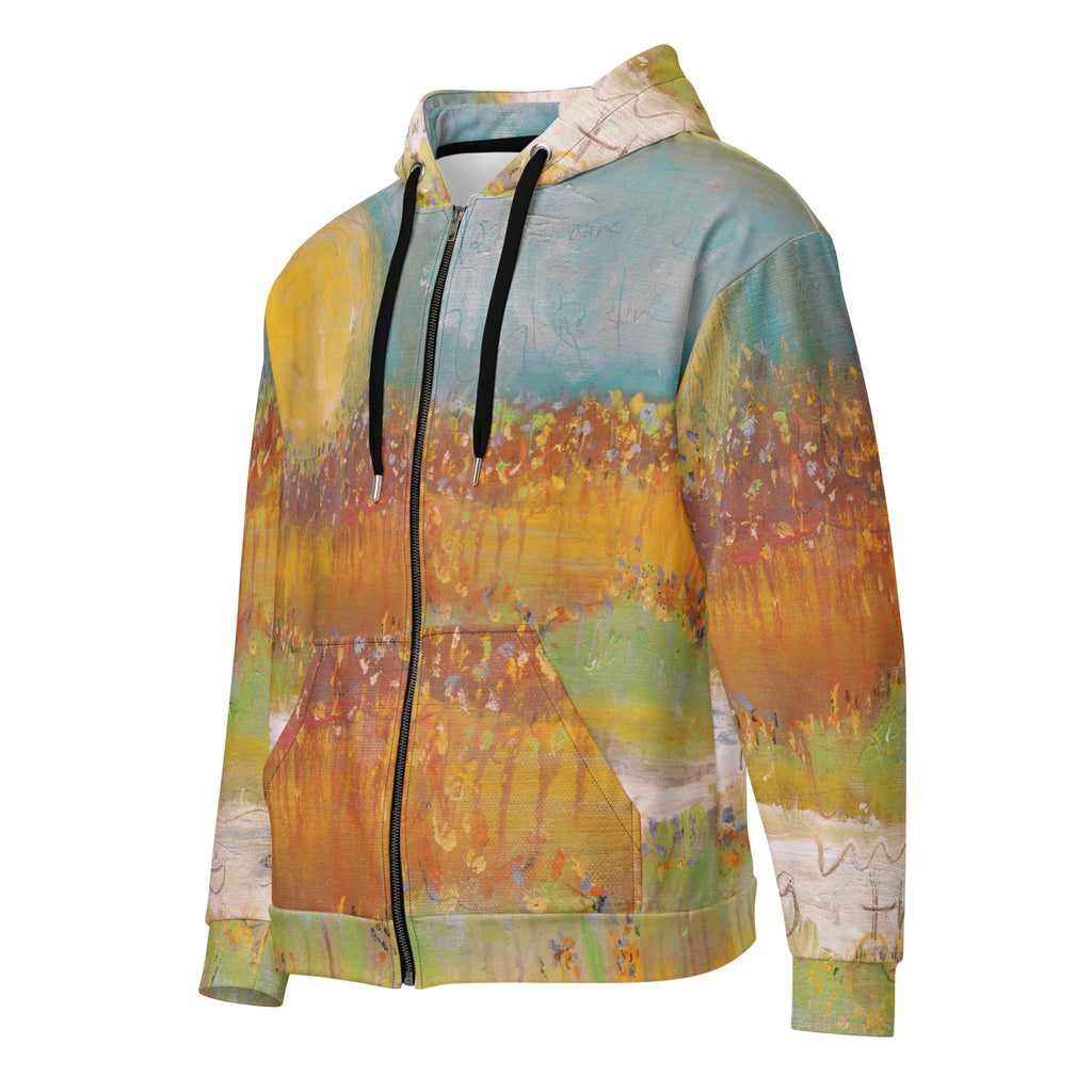 Left front three-quarter view of the FOLLOWING THE SUN zip hoodie by Klara Chavarría, golden sun over a turquoise sky and amber field, with black drawstrings