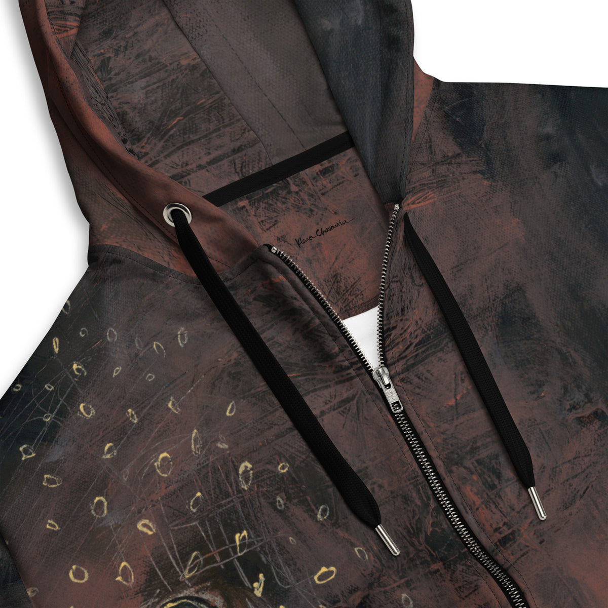 Close-up of the hood with black drawstrings, silver zipper, gold rings and a small signature