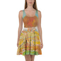 Front view of model in sleeveless skater dress with an orange sun on the bodice and gold and green swirls, GARDEN OF ILLUSIONS by Klara Chavarría