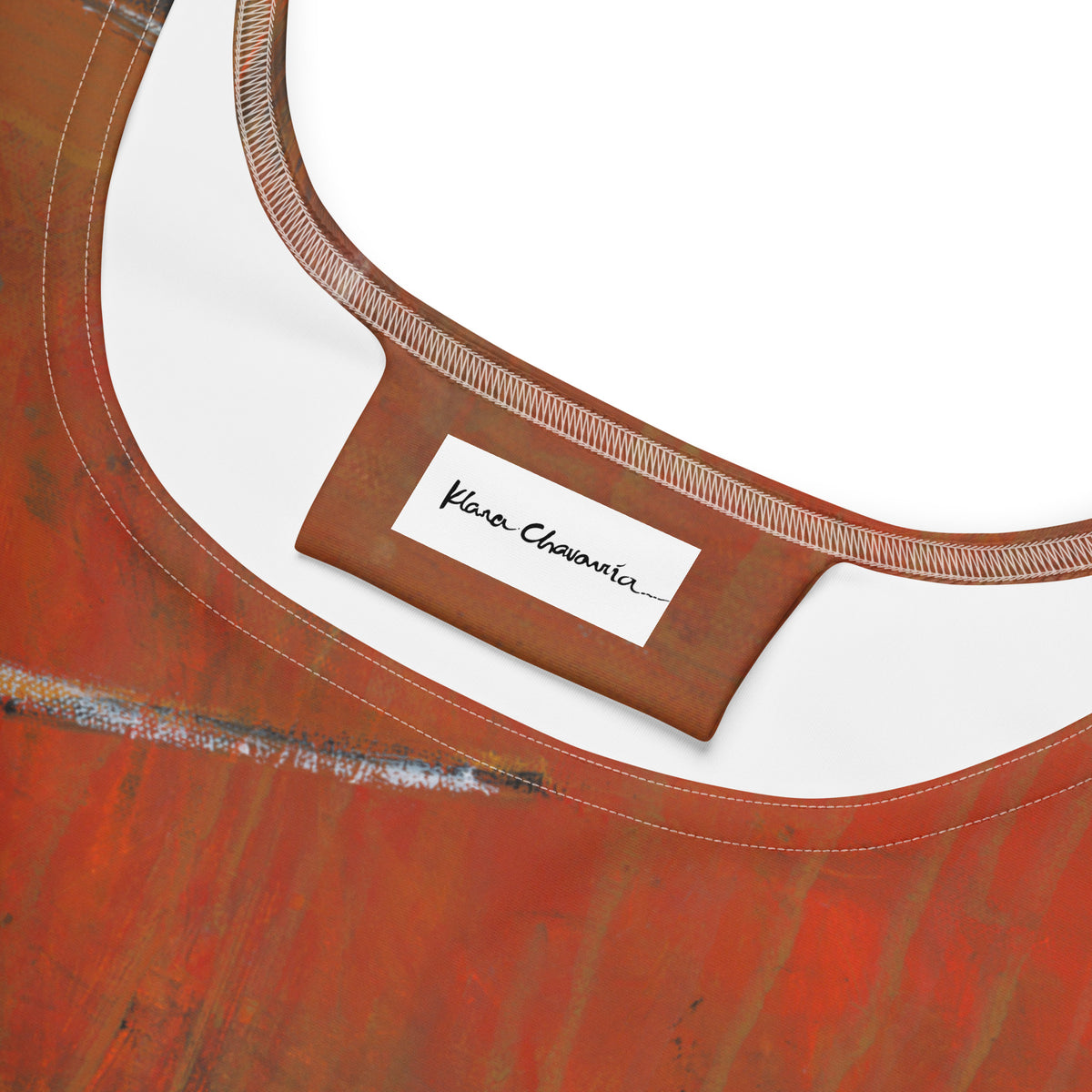 Close-up of the neckline with a white Klara Chavarría label on a rust tab