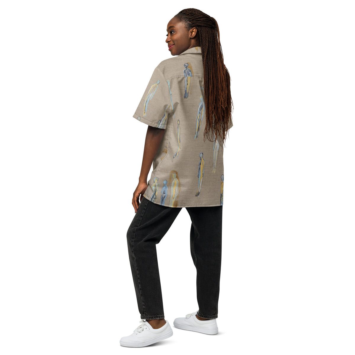 Back view of model with long braids in the shirt and black jeans, looking over her shoulder