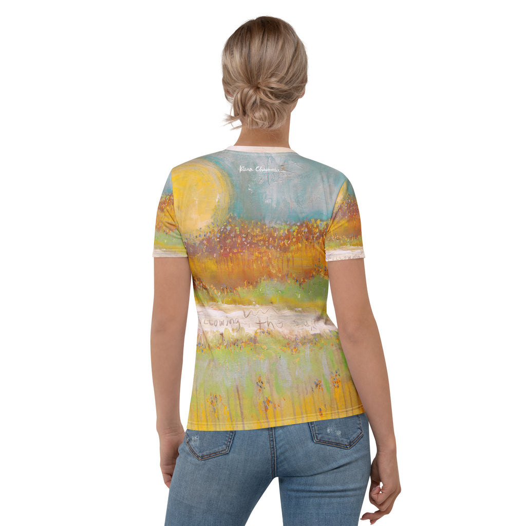 Back view of model with hair in a bun, tee showing the yellow sun, teal sky and a small signature