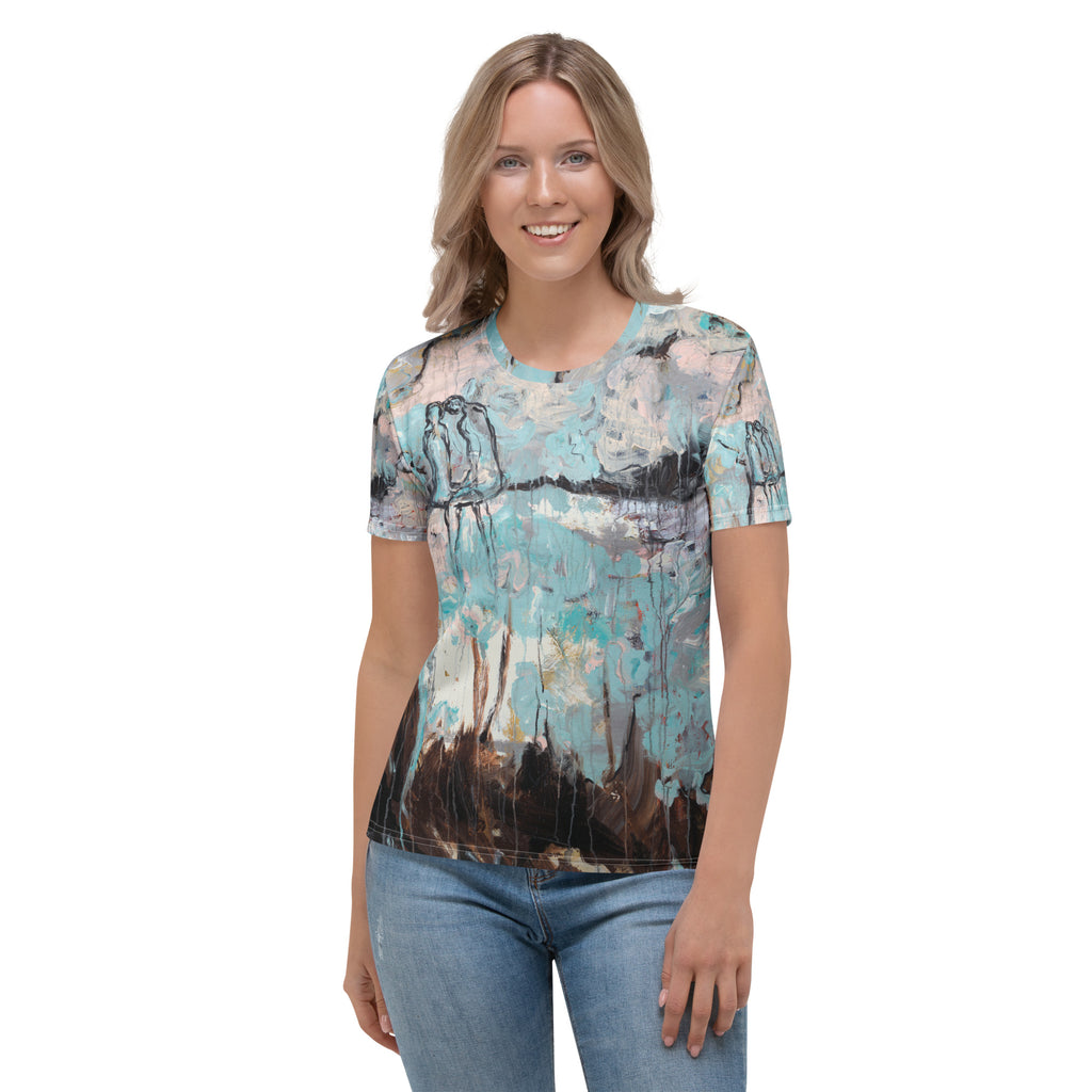 Smiling model in the aqua, pink and brown print tee and light jeans, front view