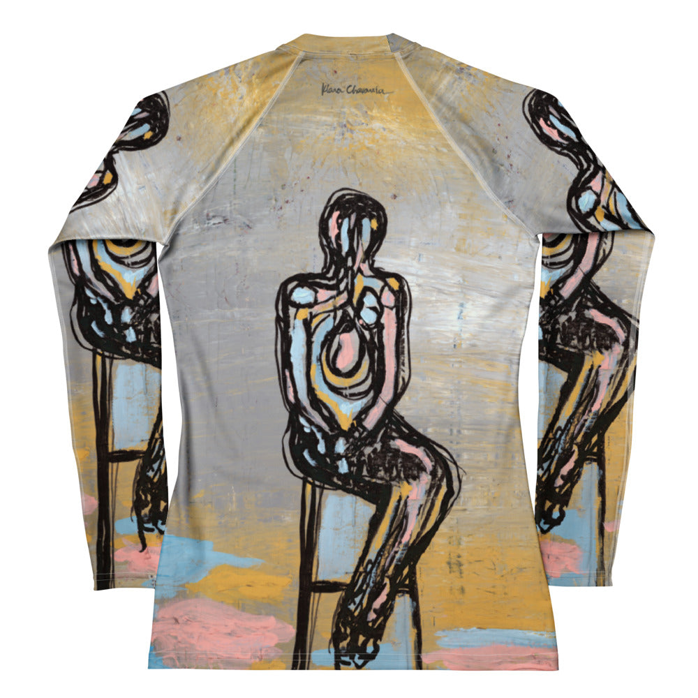 Back of the rash guard laid flat, seated figure in pink and blue with a signature at the neck