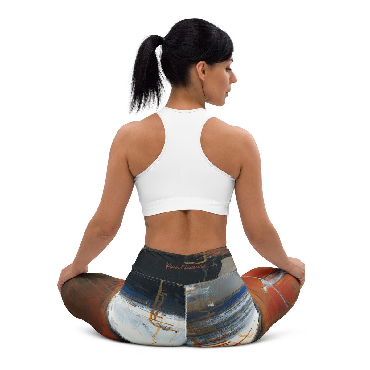 Back view of seated model in a white sports bra and the leggings, red signature on dark waistband