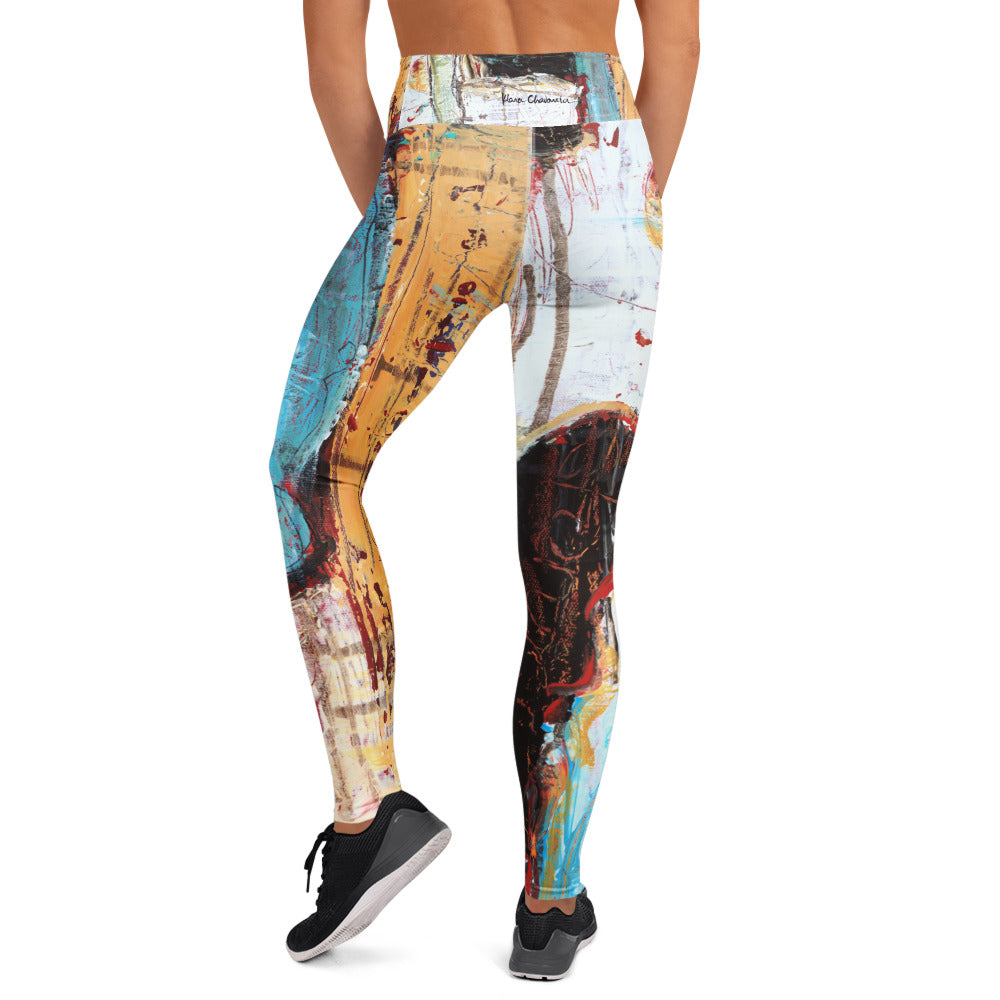 Back view of model in the leggings and black sneakers, ochre left leg and black and white right leg