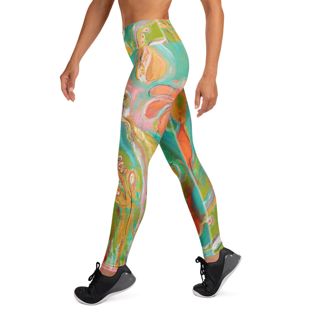 Side view of model walking in turquoise and orange painted leggings and black sneakers