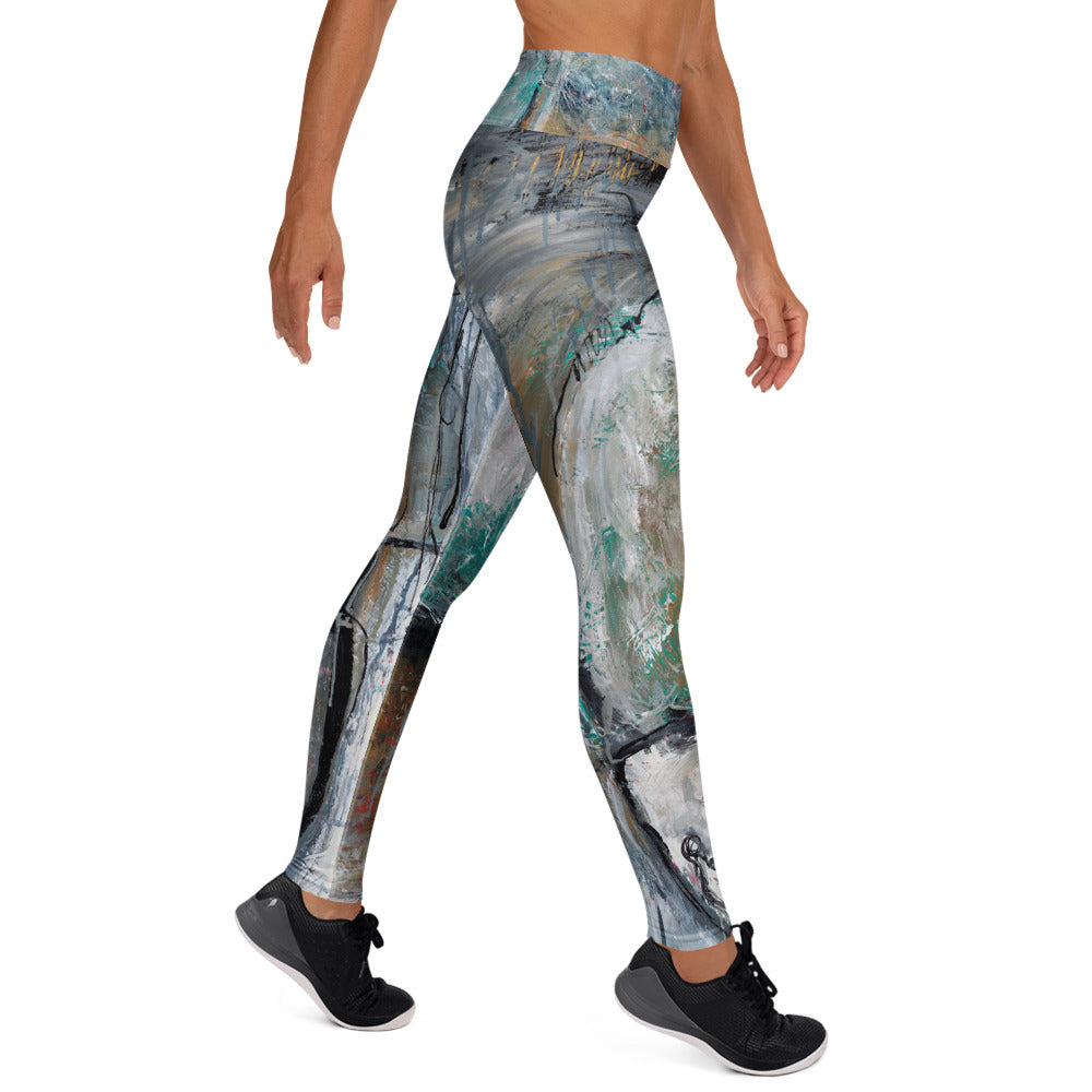 Left side view of the leggings in a walking pose, gray swirls and teal flecks down the leg
