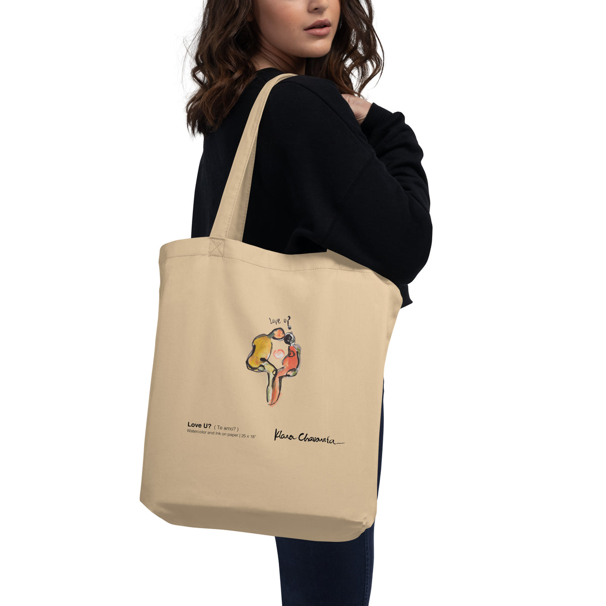 Side view of model with the tote strap over her shoulder, watercolor figures and caption visible
