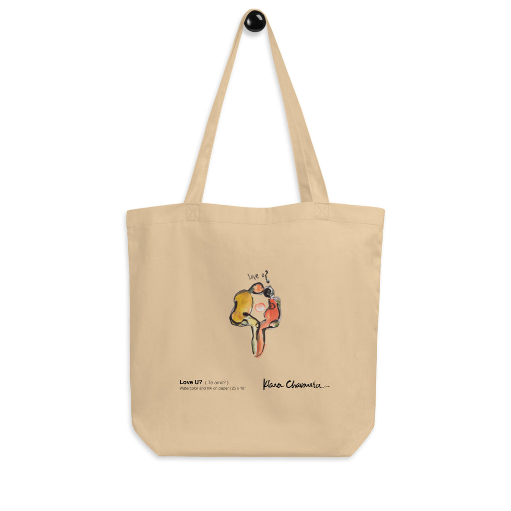 Eco tote hanging from a black wall hook, straps extended above the centered figure print