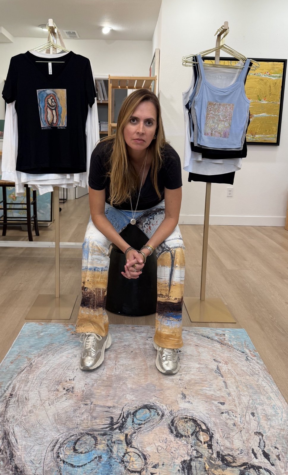Klara Chavarría, artist, seated with her art tees