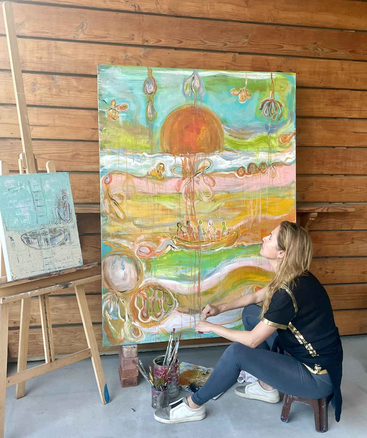 Klara Chavarría, artist, painting a large canvas in her studio