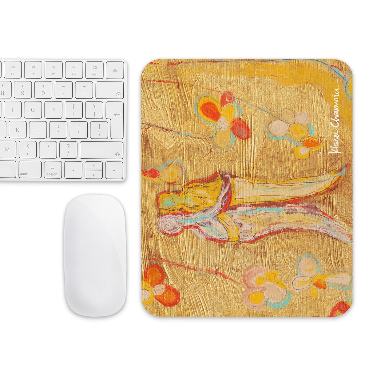 Top-down view of the gold mouse pad turned sideways next to a white keyboard and mouse