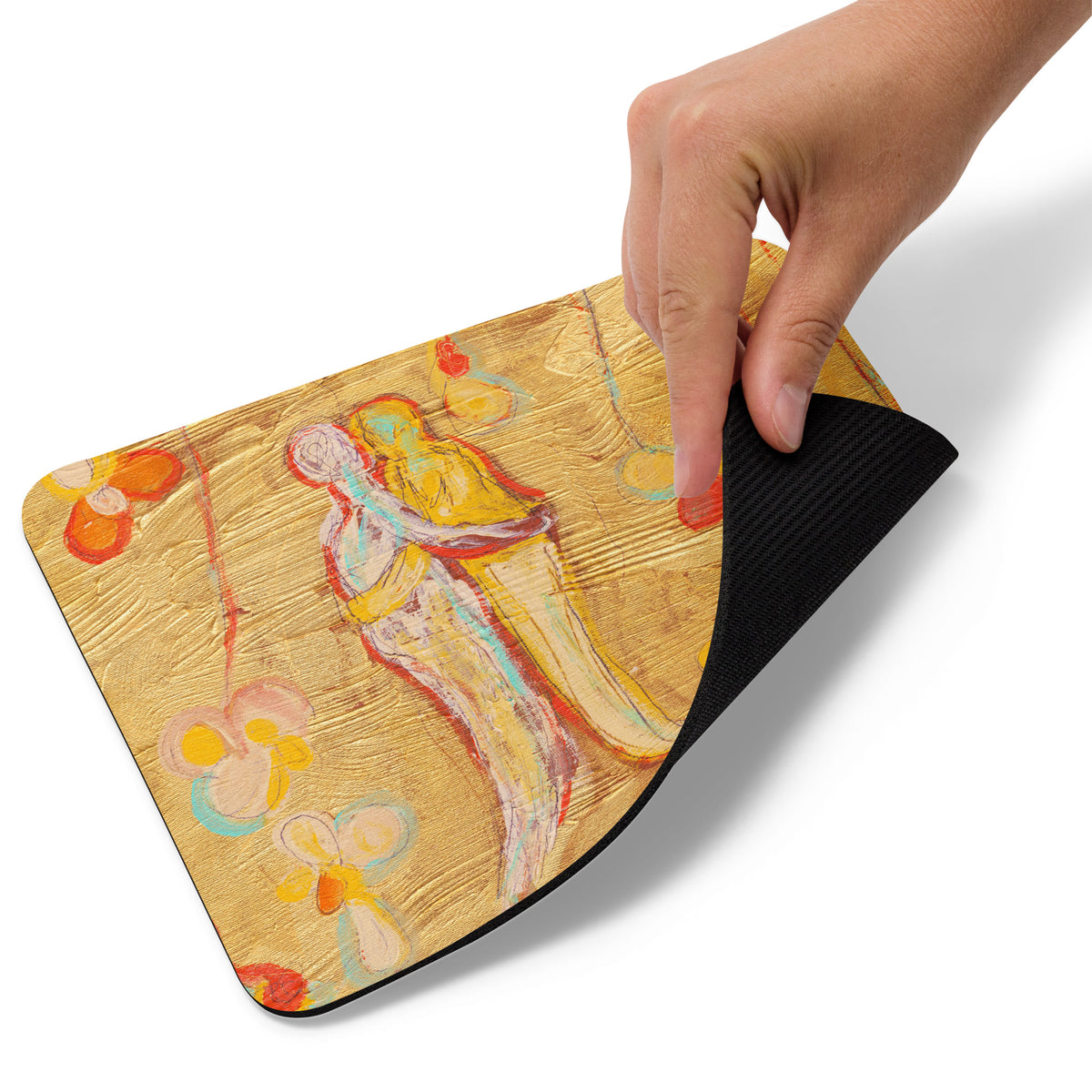 Hand peeling up a corner of the gold mouse pad to reveal its black rubber base