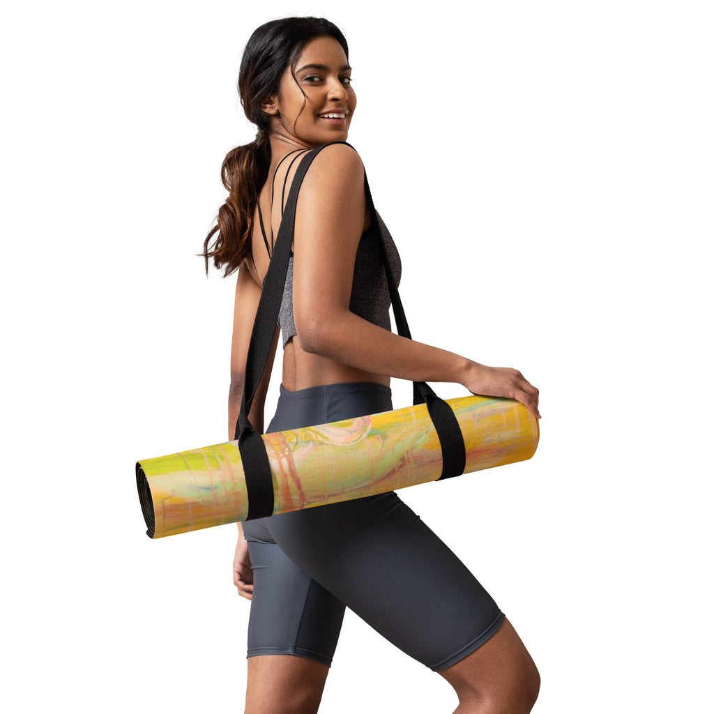 Smiling model in gray activewear carrying the rolled mat on a black shoulder strap